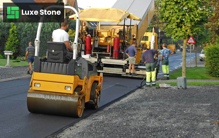 Heavy machinery laying down fresh asphalt on a construction site